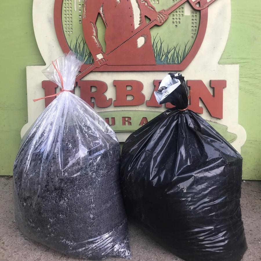 Bags of soil in front of the Urban Naturalist sign